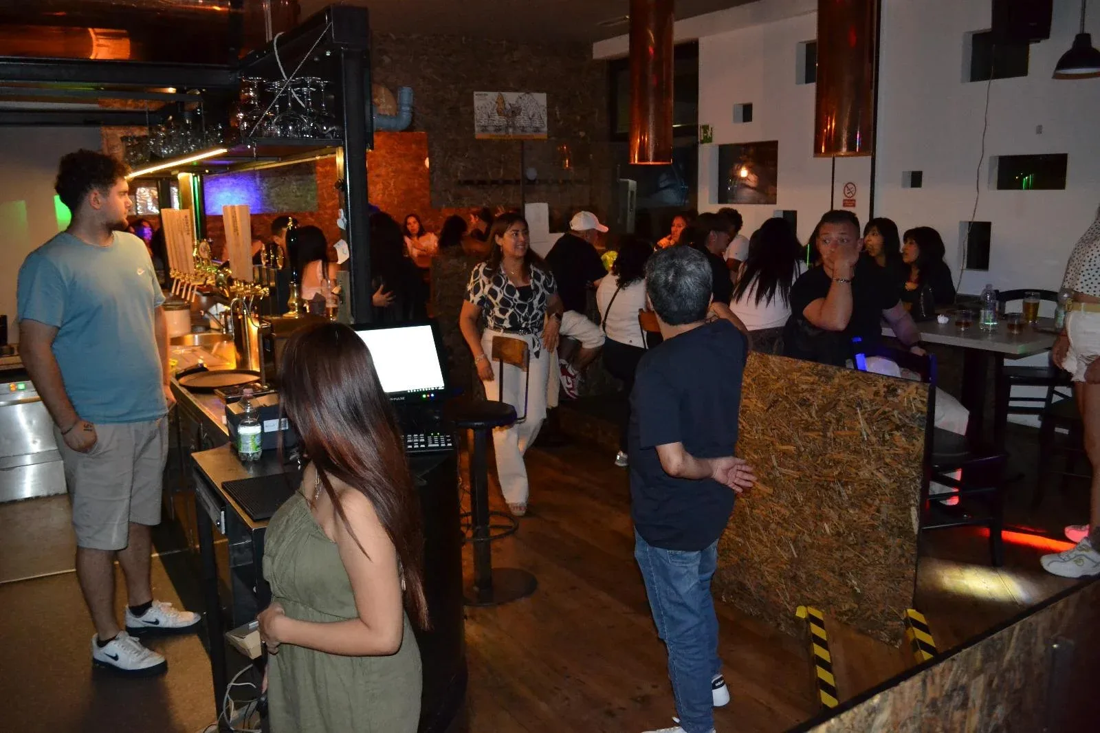 Il Rustika durante una serata Serata al Rustika: il bancone con le spine della birra e il locale pieno di gente
